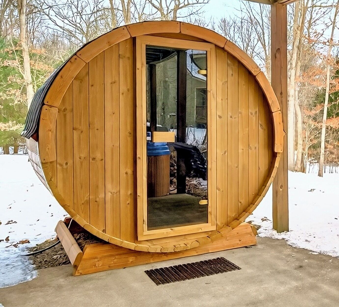 Estructura de sauna de madera con puerta, un banco en el interior y una pequeña ventana.