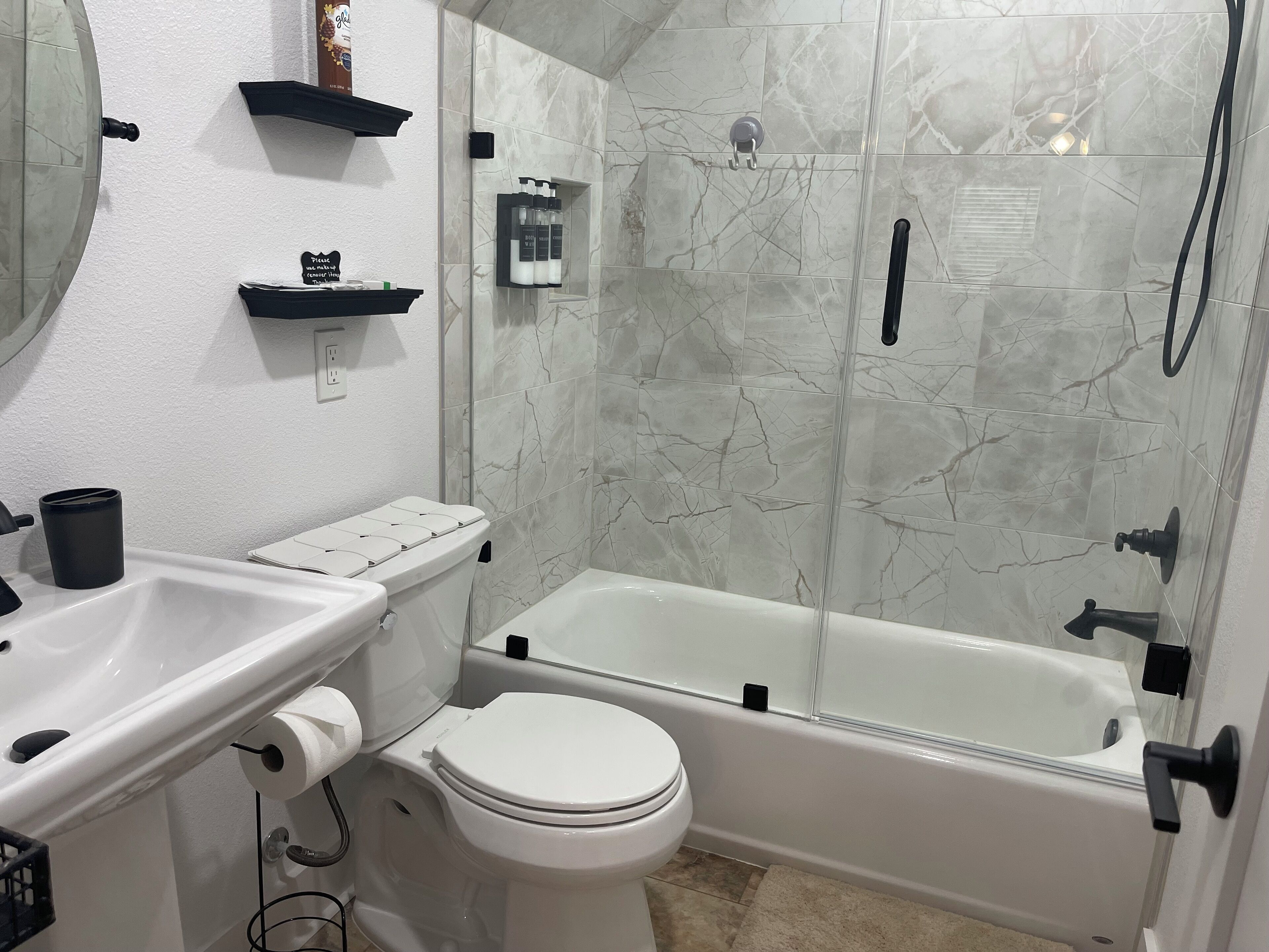 A bathroom with a toilet, sink, and bathtub.