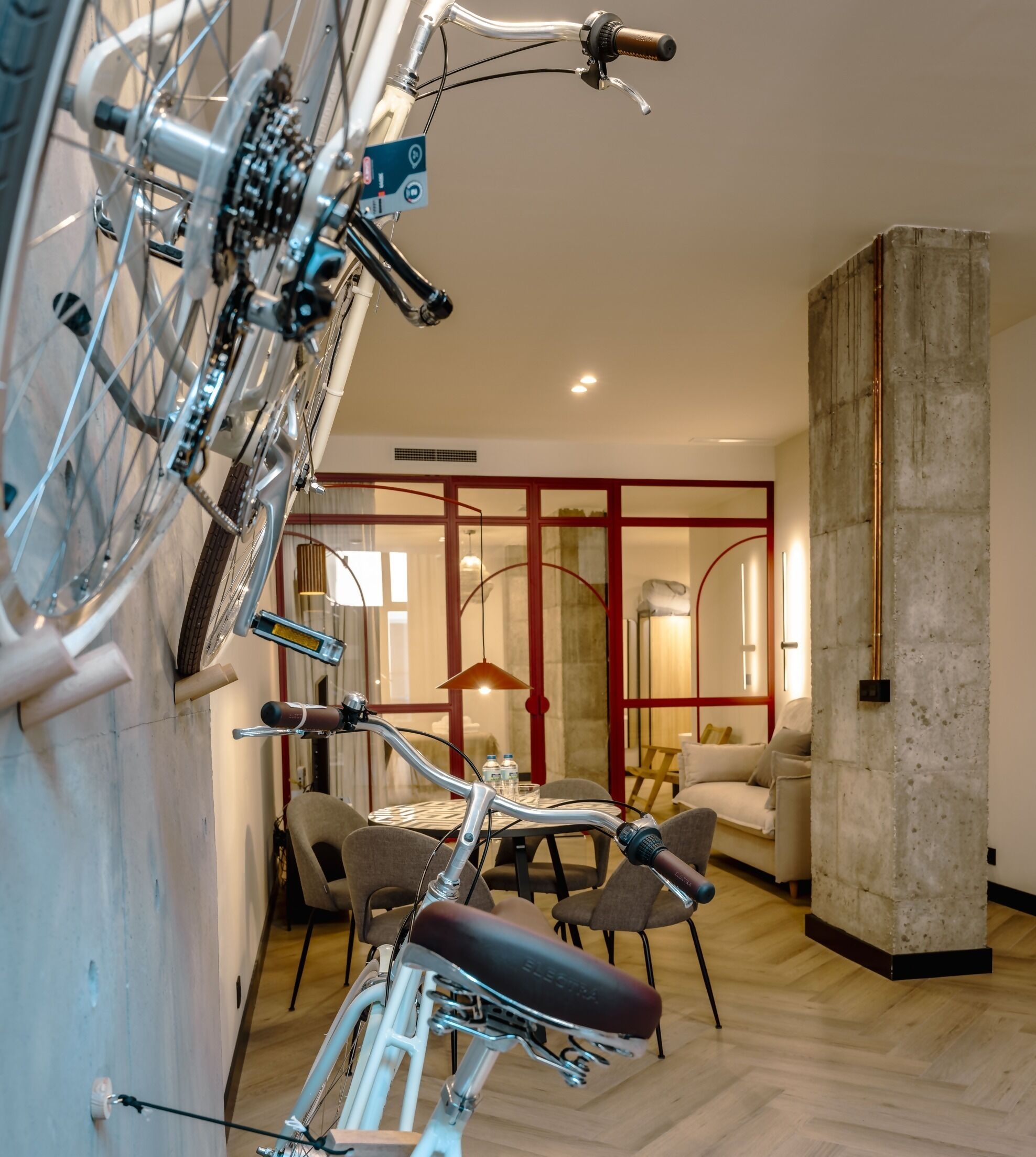 Un intérieur moderne avec un vélo, un coin repas et une grande colonne.