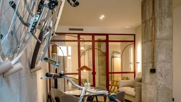 Un intérieur moderne avec un vélo, un coin repas et une grande colonne.