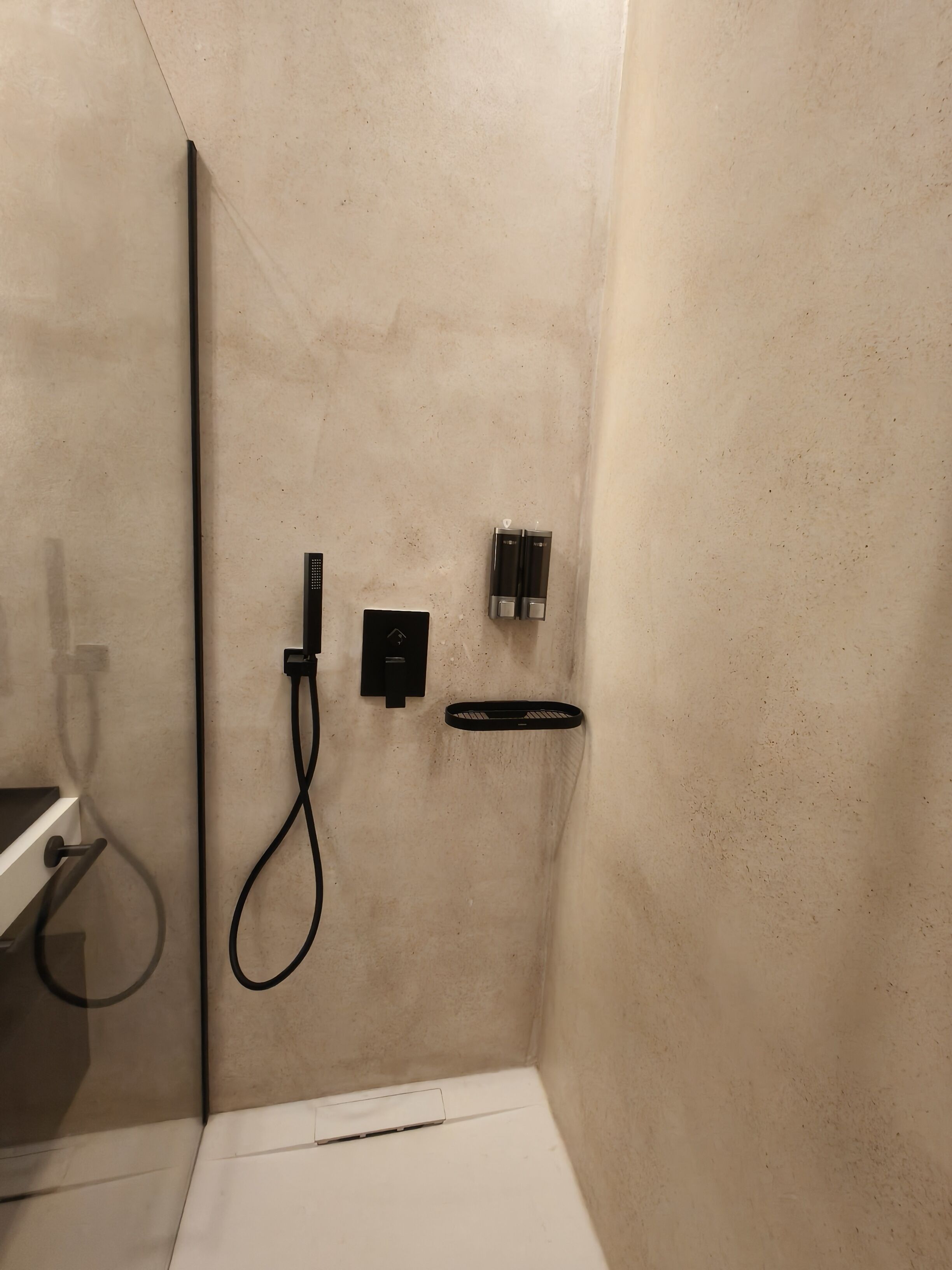 A small, modern bathroom with a shower, a toilet, and a sink.