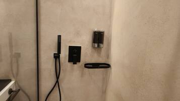 A small, modern bathroom with a shower, a toilet, and a sink.