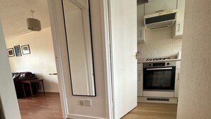 Cozinha moderna com armários brancos, forno embutido e fogão a gás.