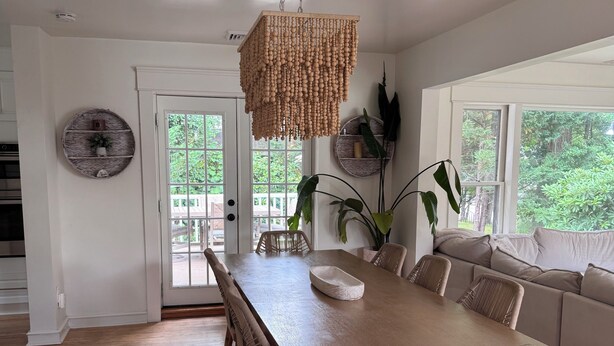 A dining area with a wooden table, wicker chairs, and a hanging light fixture. - Beautiful 3-bedroom house minutes from Swarthmore! (Morton)