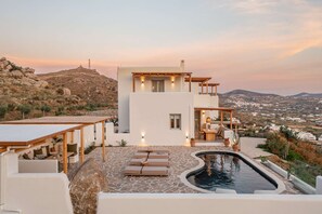 Une villa moderne dotée d’une piscine, d’un espace extérieur aménagé et offrant une vue sur la campagne.