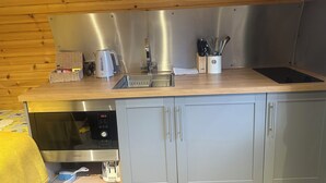 Eine moderne Küche mit Edelstahlgeräten, einer Holz Arbeitsplatte und grauen Schränken.