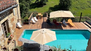 A pool with lounge chairs and umbrellas, surrounded by a stone building and a view of a green landscape. - Holiday Home “Le Pentadou – Gîte Lou Costalou” with Pool, Private Terrace & Wi-Fi (Felzins)