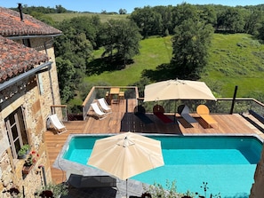 A pool with lounge chairs and umbrellas, surrounded by a stone building and a view of a green landscape. - Holiday Home “Le Pentadou – Gîte Lou Costalou” with Pool, Private Terrace & Wi-Fi (Felzins)