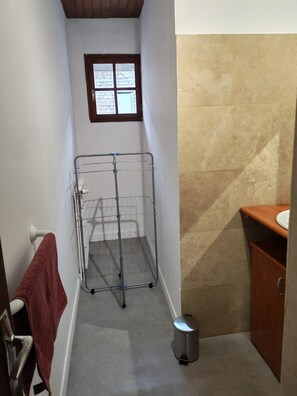 A narrow bathroom with a metal drying rack, a small window, a sink, and a trash can. - Les Nids Pyrénéens (Castillon de larboust)