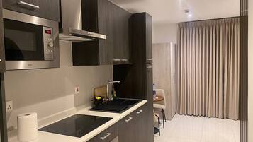 Deluxe Studio Suite, Balcony, City View | Private kitchen | Fridge, microwave, oven, stovetop