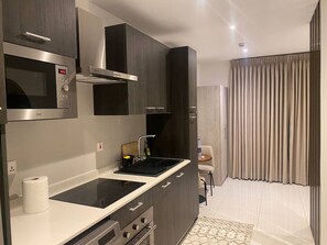 Deluxe Studio Suite, Balcony, City View | Private kitchen | Fridge, microwave, oven, stovetop - Unique Abodes (Accra)