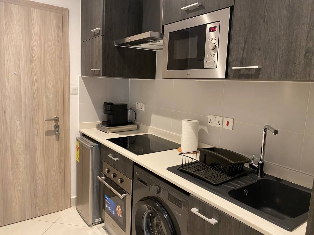 A modern kitchen with a microwave, stove, dishwasher, and sink.