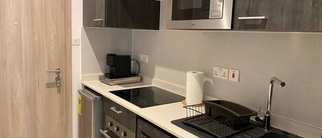 A modern kitchen with a microwave, stove, dishwasher, and sink.