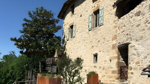 A stone building with a wooden deck, a stone wall, and a tree. - Cachou Guest Room with Shared Pool, Private Terrace and Wi-Fi (Felzins)