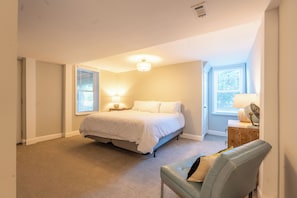 A bedroom with a bed, bedside lamps, a wooden dresser, and a window with blinds. - Turnkey cozy living in this beautifully furnished 2-bd, 1-bath in Thunderbolt (Thunderbolt)