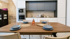 A modern kitchen with a built-in oven, microwave, and a large grey cabinet above the countertop. - [La Portulaca] Cozy Apt. in Molfetta (Molfetta)