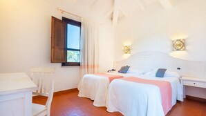 Un dormitorio con dos camas, un escritorio y una ventana con cortinas.
