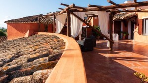 Terraza en la azotea con escalones de piedra, pérgola de madera y suelo de baldosas.