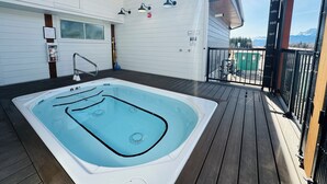 A hot tub on a wooden deck with a view of mountains. - Skyridge Resort -Near Banff Entrance (Harvie Heights)