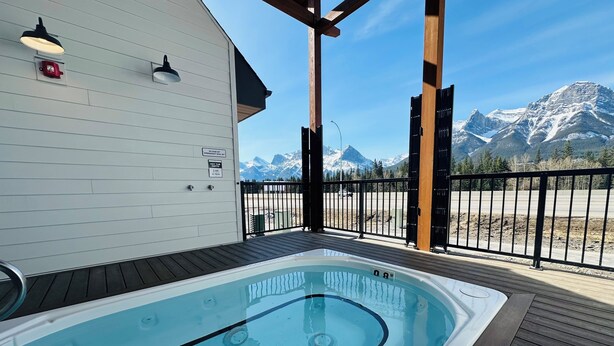 A hot tub on a wooden deck with a mountain view. - Skyridge Resort -Near Banff Entrance (Harvie Heights)