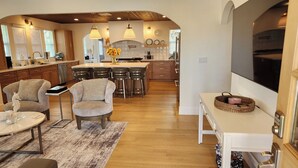 A modern kitchen with a central island, wooden flooring, and pendant lighting. - Stunning 4BR/3BA Home in Sunset Cliffs – Walk to Ocean (San Diego)