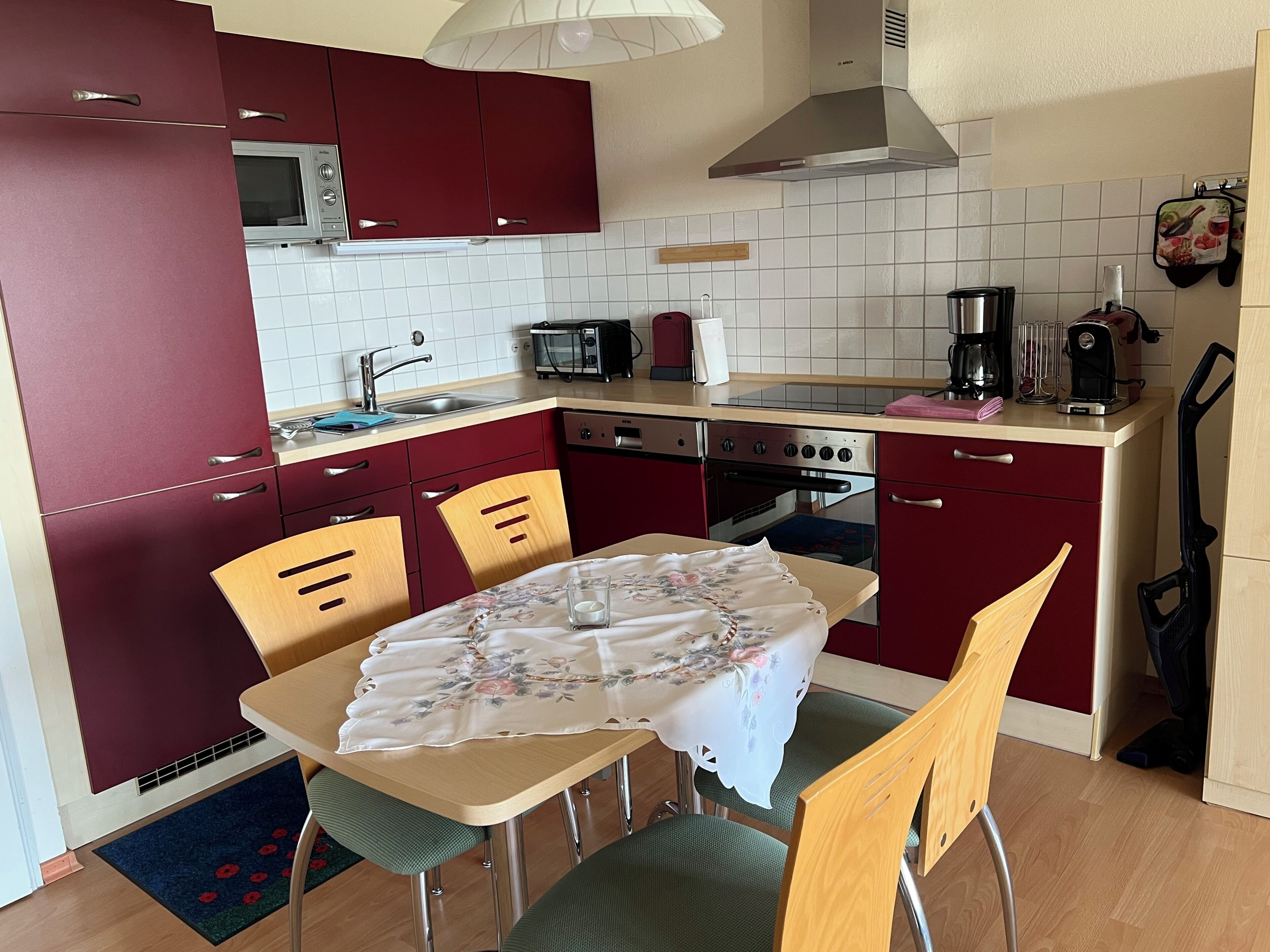 A compact kitchen with red cabinets, a microwave, a toaster, and a coffee maker.