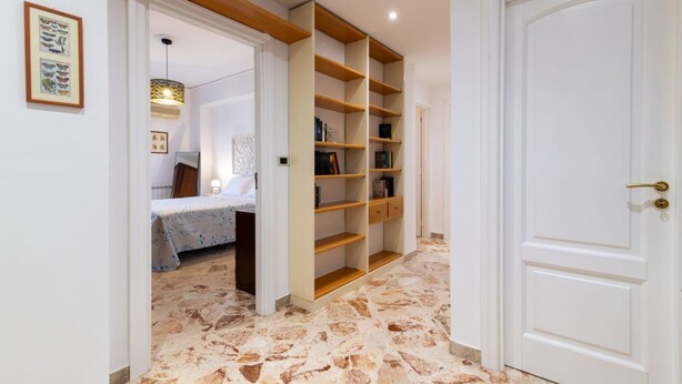 Una habitación con una cama, una estantería y una puerta.