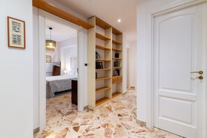 Une pièce avec un lit, une bibliothèque et une porte.