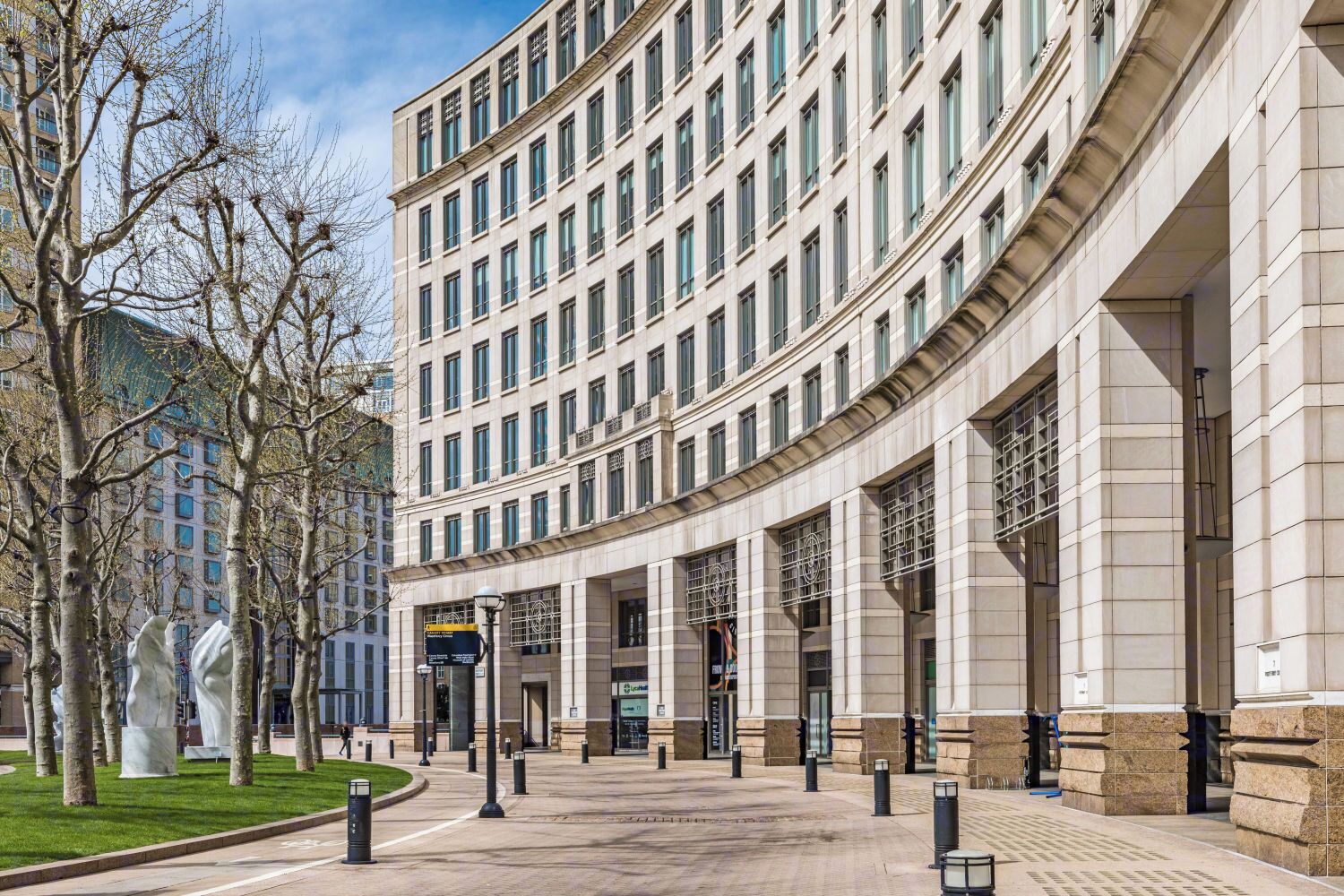 A modern building with a curved facade, large windows, and a central entrance.