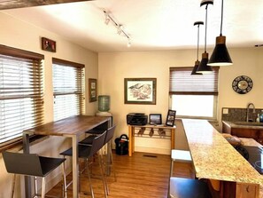 A compact kitchen with a central island, bar stools, and pendant lighting. - Park City Ski-In Townhouse - Hot Tub - Sleeps 7 (Park City)