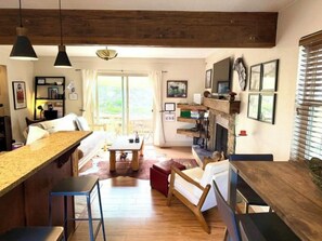 A spacious living area with a wooden ceiling, a kitchen with a bar counter, and a fireplace. - Park City Ski-In Townhouse - Hot Tub - Sleeps 7 (Park City)