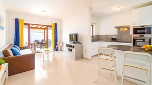 Ein modernes Apartment mit Wohnzimmer, Essbereich und Küche.
