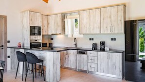 Een moderne keuken met houten kastjes, een zwart aanrechtblad en een ingebouwde oven.