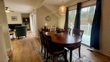 Un espace repas comprenant une table en bois, des chaises et un luminaire suspendu.