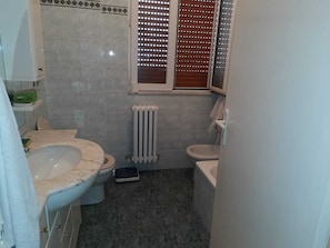 Ein Badezimmer mit Toilette, Bidet und Heizkörper.