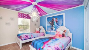 Ein Schlafzimmer mit zwei Betten, einem Deckenventilator, einem Fenster mit Jalousien und einem Wandbild.