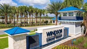 A sign for 'Windsor Island Resort' with a clear view of the surrounding palm trees and a body of water. - Modern 5BR Home w/ Pool at Windsor Island (Davenport)