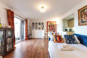 Ett hotellrum med en säng, ett skrivbord, en bokhylla och en matplats.