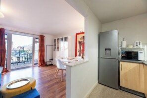 Eine moderne Küche mit Kühlschrank, Mikrowelle und einem Essbereich mit Tisch und Stühlen.