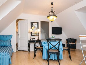 A dining area with a table, chairs, and a chandelier. - 4 Star Holiday Home in Skanderborg (Skanderborg)