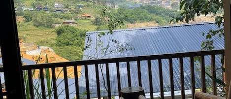 A balcony with a view of solar panels and a mountainous landscape.