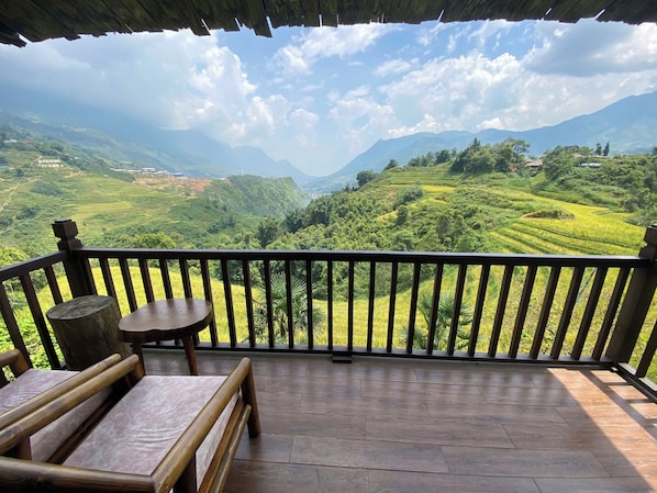 A wooden deck with a table and benches, overlooking terraced fields and mountains. - Chapa Ecolodge (Sa Pa)