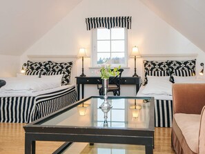 A hotel room with two beds, a glass coffee table, a desk, and a chair. - 4 Star Holiday Home in Skanderborg (Skanderborg)