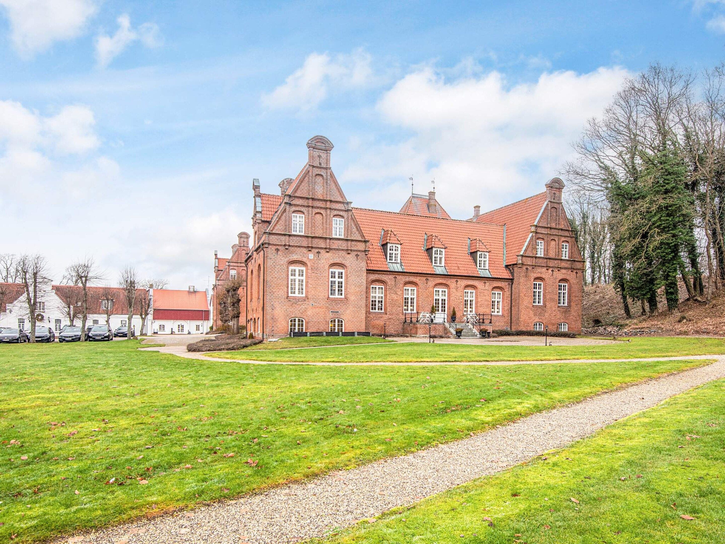 Un grand bâtiment historique en briques, doté de nombreuses fenêtres et d’une tour imposante.