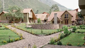 A courtyard with stone pathways, surrounded by buildings with tiled roofs and stone walls.