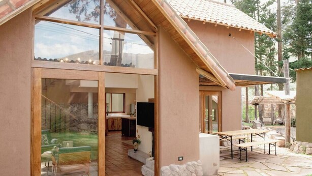 A modern house with a large glass door leading to a patio area.