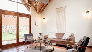 A cozy living room with a sofa, two armchairs, a coffee table, and a fireplace.