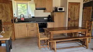 Una cucina rustica con mobili in legno, un tavolo da pranzo e un forno a incasso.