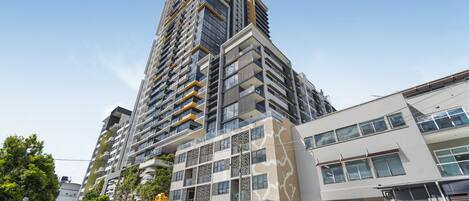 A high-rise building with multiple balconies and a modern architectural design.