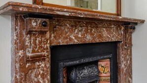 A fireplace with a marble surround and a decorative mantelpiece. - Ground Floor Apartment Beverley House (Cromer)